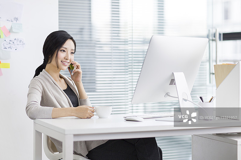 年轻女子在办公室打电话图片素材