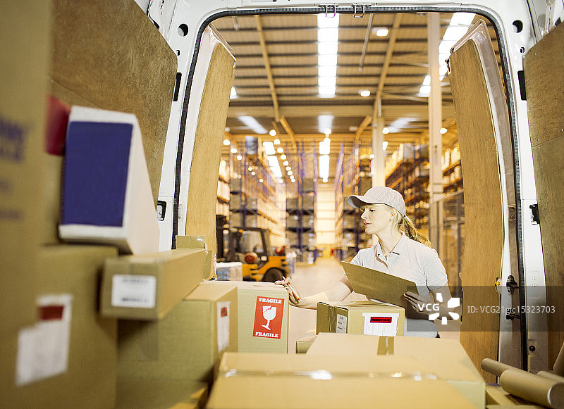 配送员女孩在货车上检查箱子图片素材