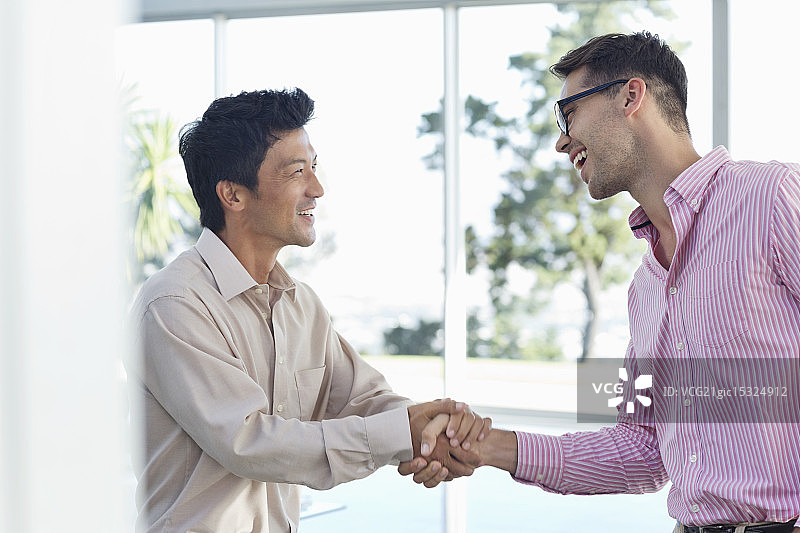 在办公室里握手的商人图片素材