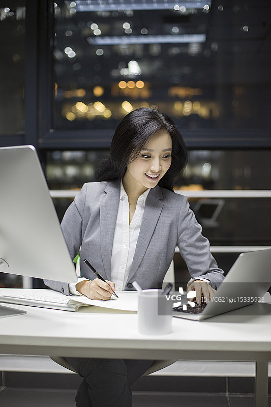 快乐的商务女士在办公室加班图片素材