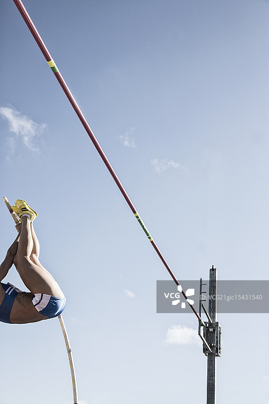 撑杆跳运动员接近横杆图片素材