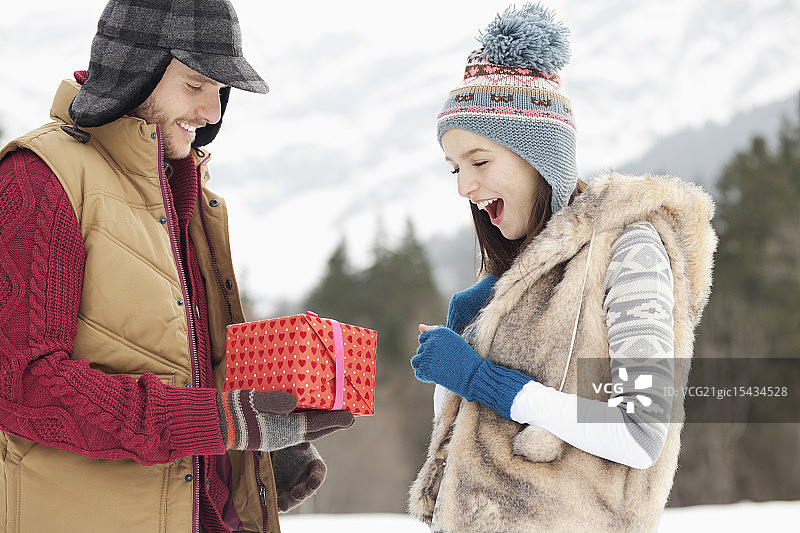 男人在雪地里给女人送礼物图片素材