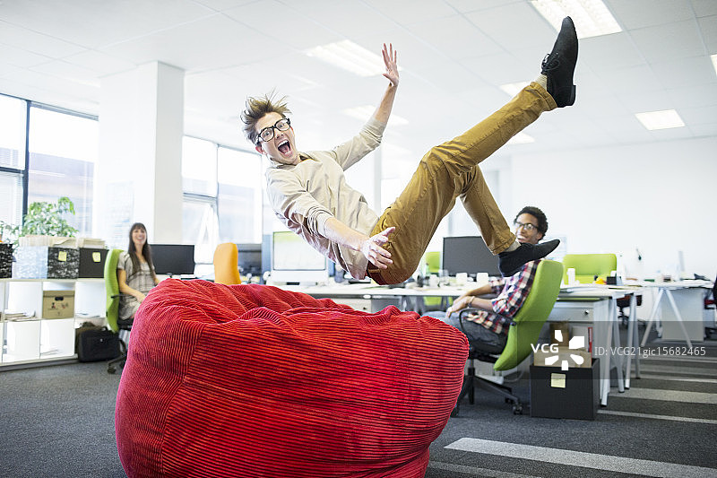 商人跳入办公室的豆袋椅图片素材