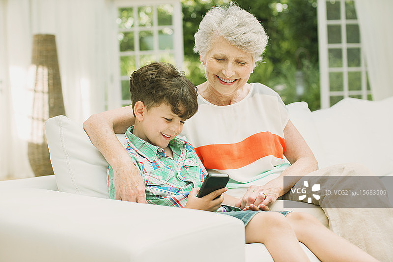 年长的女人和孙子使用手机图片素材