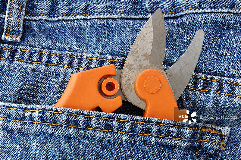 蓝色牛仔裤口袋里的修枝剪图片素材