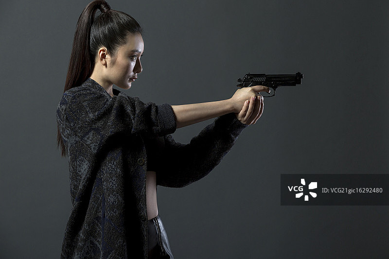 拿着手枪的青年女人图片素材