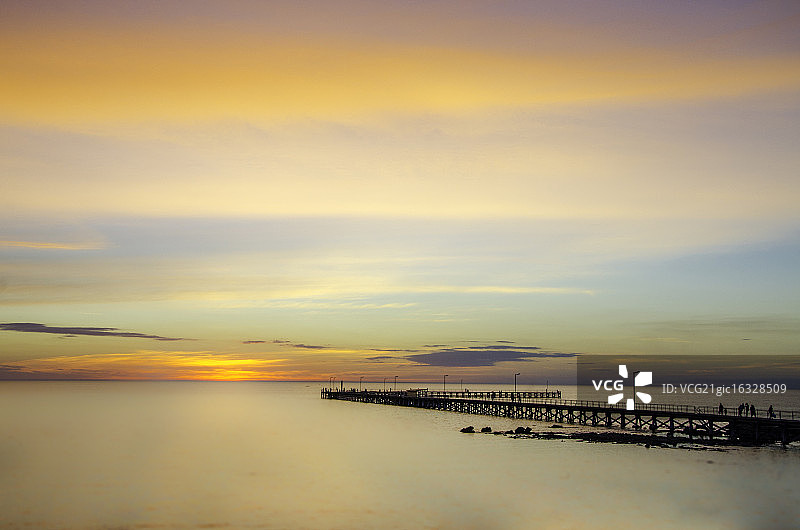 海上码头稀疏日落与柔和云朵图片素材