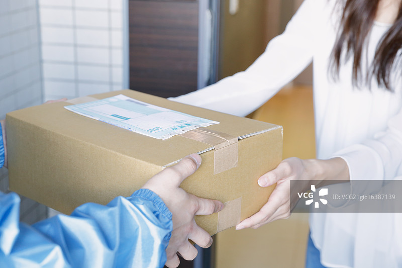 日本年轻女子从送货员那里收到包裹图片素材
