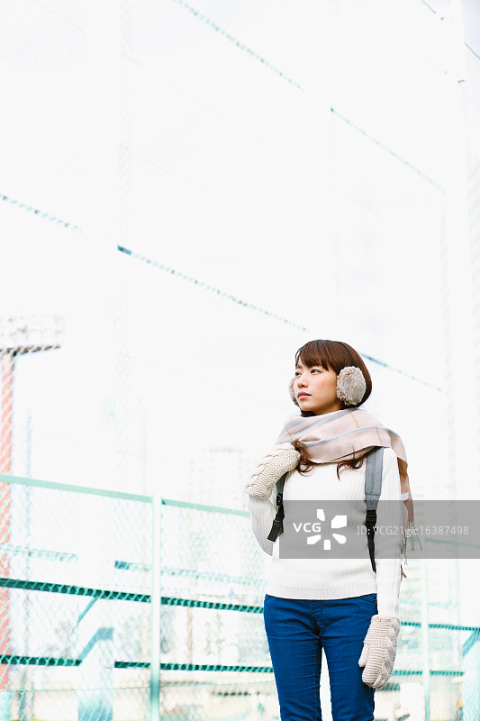 在冬日晴天戴着围巾的有吸引力的日本女人图片素材