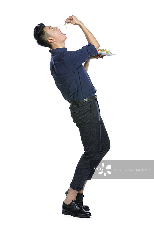 青年男子端着一盘生菜沙拉图片素材