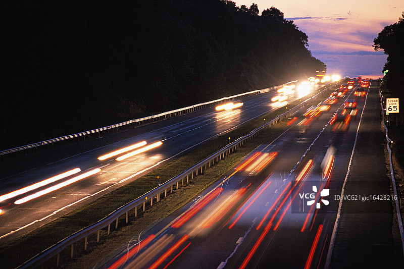 黄昏时分在高速公路上行驶的汽车图片素材