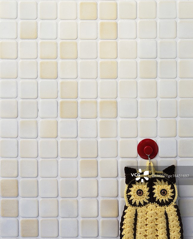挂在瓷砖上的钩针猫头鹰图片素材
