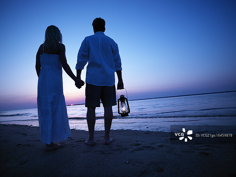 情侣观看日落海滩图片素材