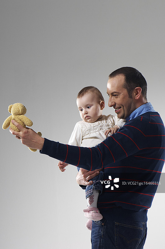 父亲给女儿看小熊图片素材