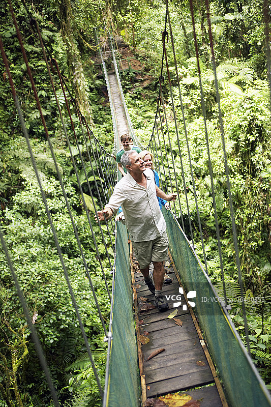 游客团体穿越荒野地区的绳索桥图片素材