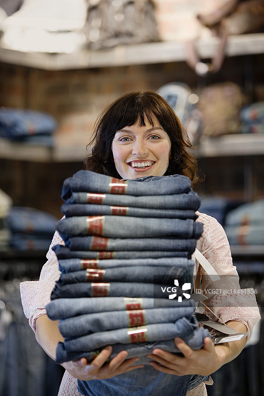 拿着一堆牛仔裤的女人图片素材