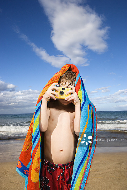 在海滩上拍照的男孩图片素材