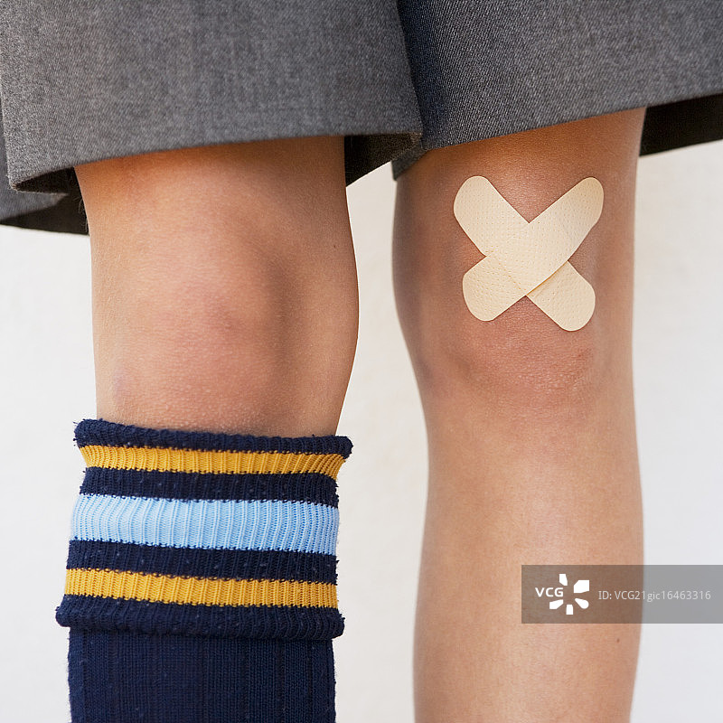 膝盖上贴着创可贴的学龄男童图片素材