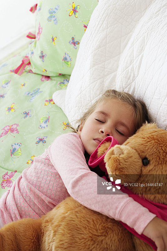 抱着泰迪熊睡觉的女孩图片素材