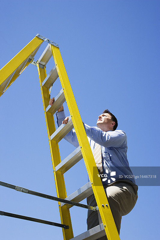 在户外爬梯子的商人图片素材