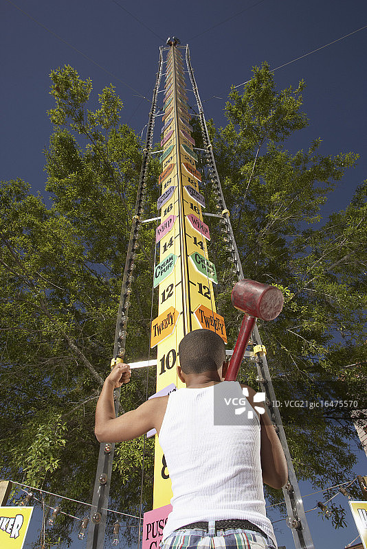 玩力量测试游戏的小男孩图片素材