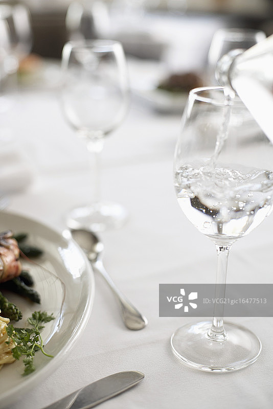 将矿泉水倒入玻璃杯中图片素材