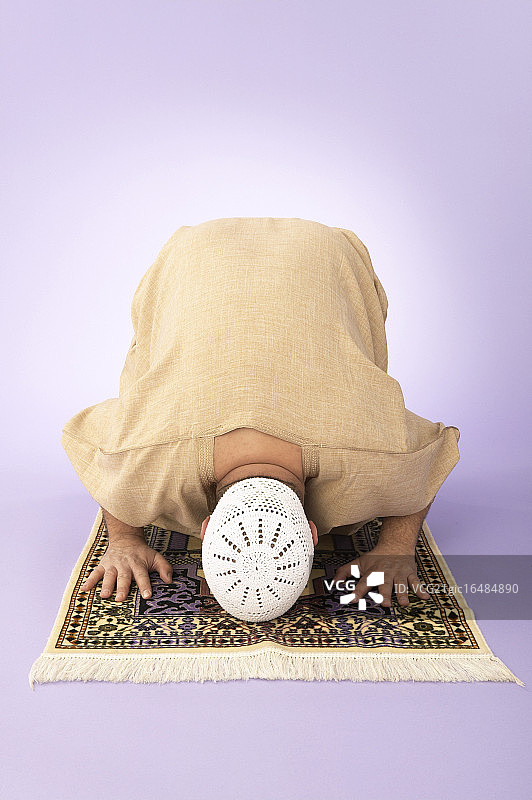 男子在祈祷垫上祈祷图片素材
