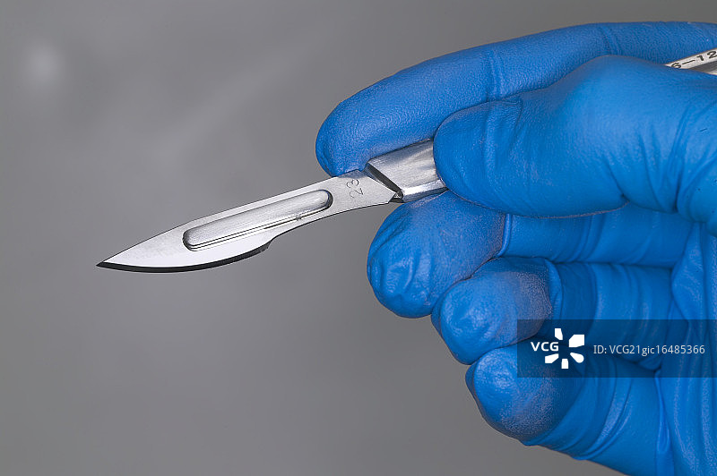 戴乳胶手套的手与手术刀图片素材