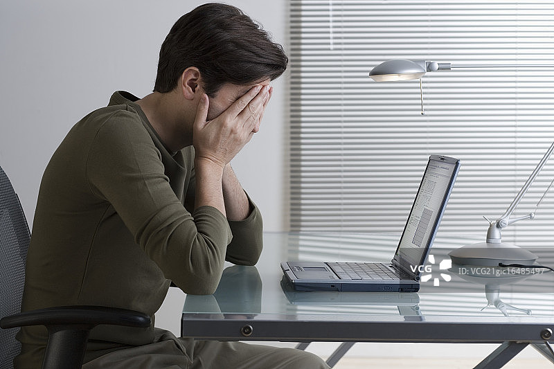 使用笔记本电脑的沮丧的男人图片素材