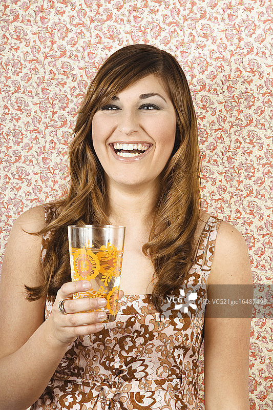 微笑的年轻女人拿着一杯水图片素材