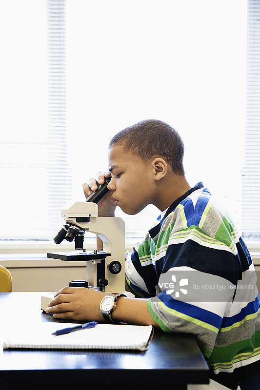 男孩正在观察显微镜图片素材