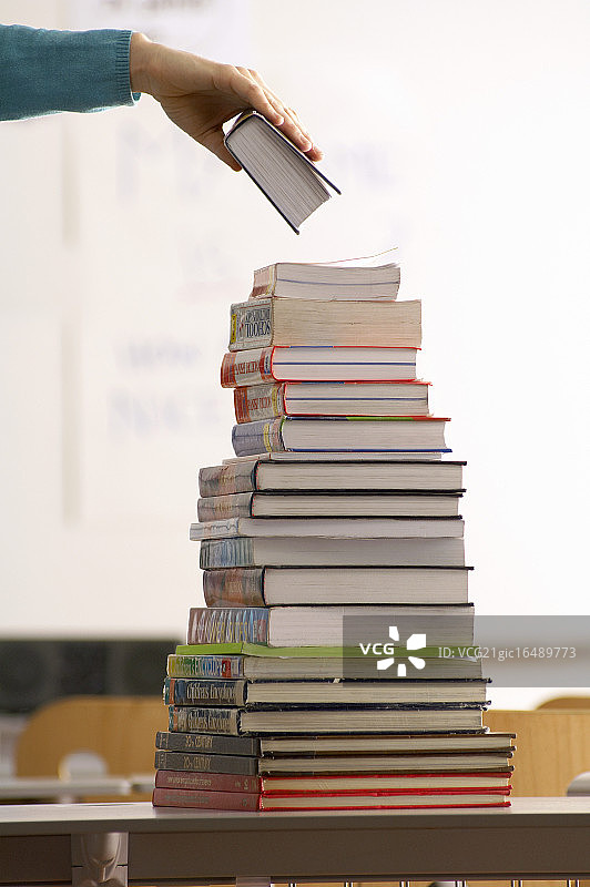 将最后一本书放在书堆上图片素材
