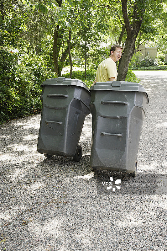 在车道上拉垃圾箱的男人图片素材