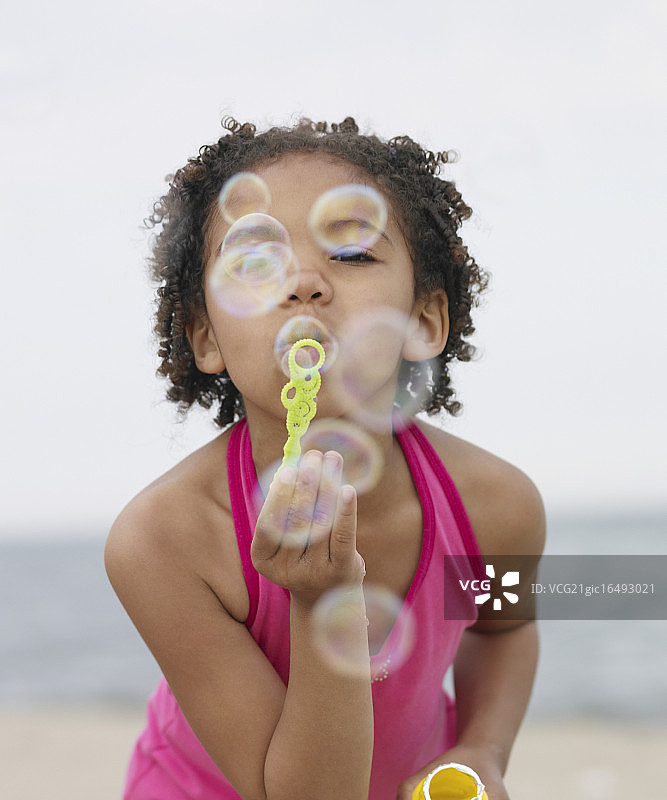 在海滩上吹泡泡的女孩图片素材