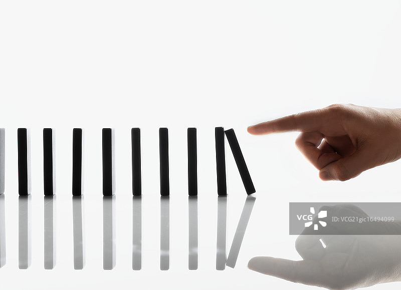 摆弄多米诺骨牌的商人图片素材