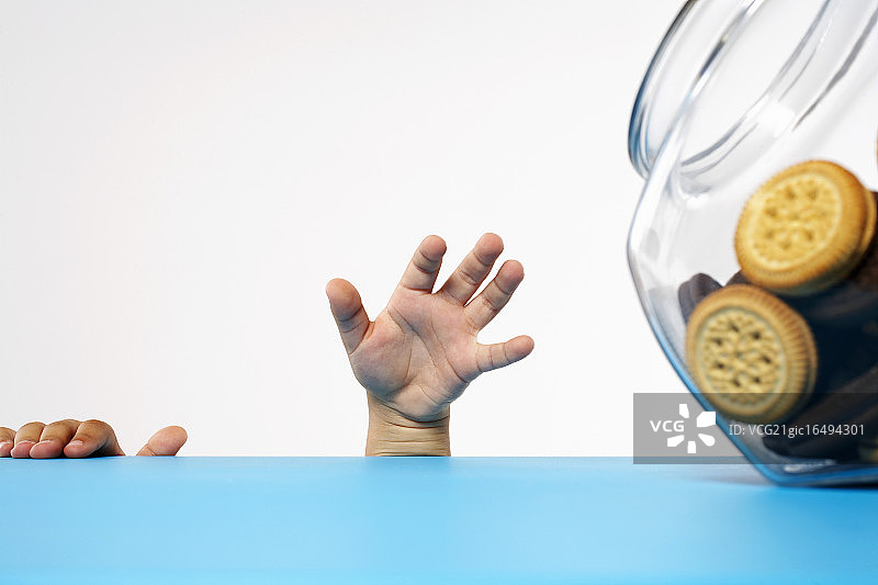 男孩伸手去拿饼干罐图片素材