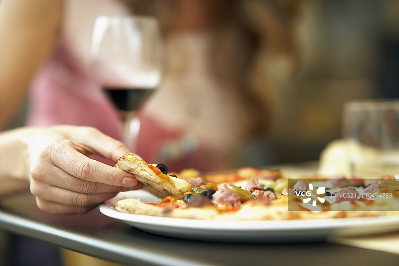 女人在路边咖啡馆吃披萨图片素材