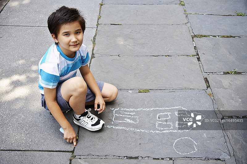 男孩在人行道上绘画图片素材