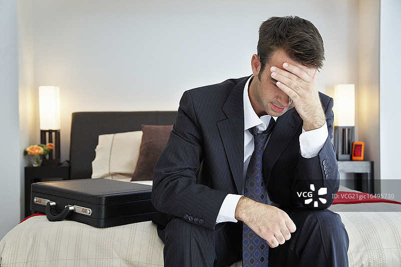 坐在床上的压力大的商人图片素材