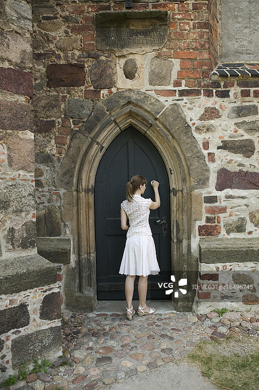 女人敲教堂的门图片素材