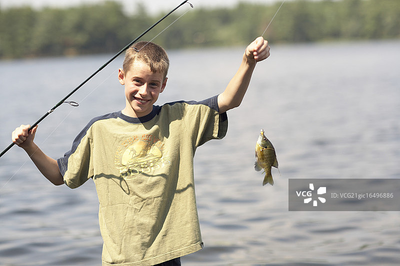 男孩炫耀他的渔获图片素材