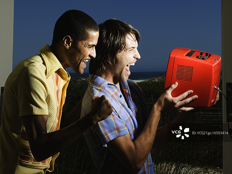 两个兴高采烈的男人在看电视体育节目图片素材