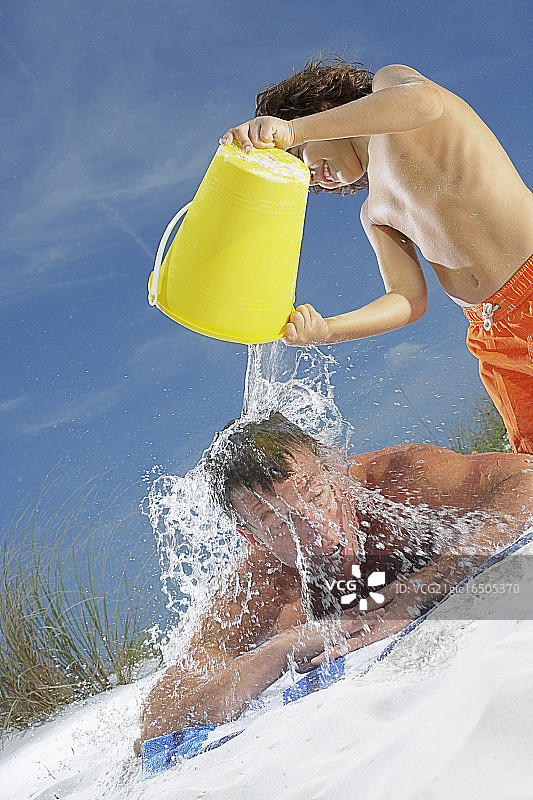 小男孩给爸爸泼水图片素材