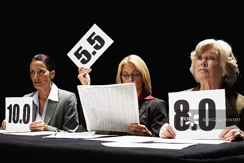 阅读报纸的公正比赛评委图片素材