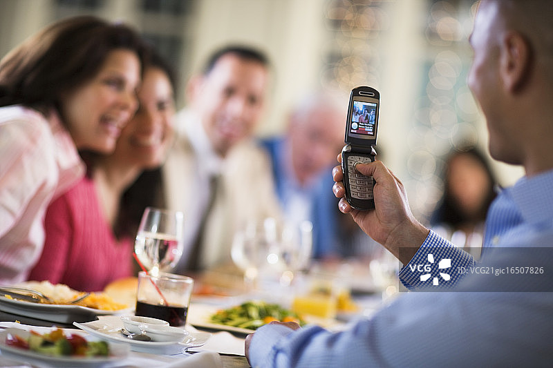 男子在餐厅用相机手机拍照图片素材