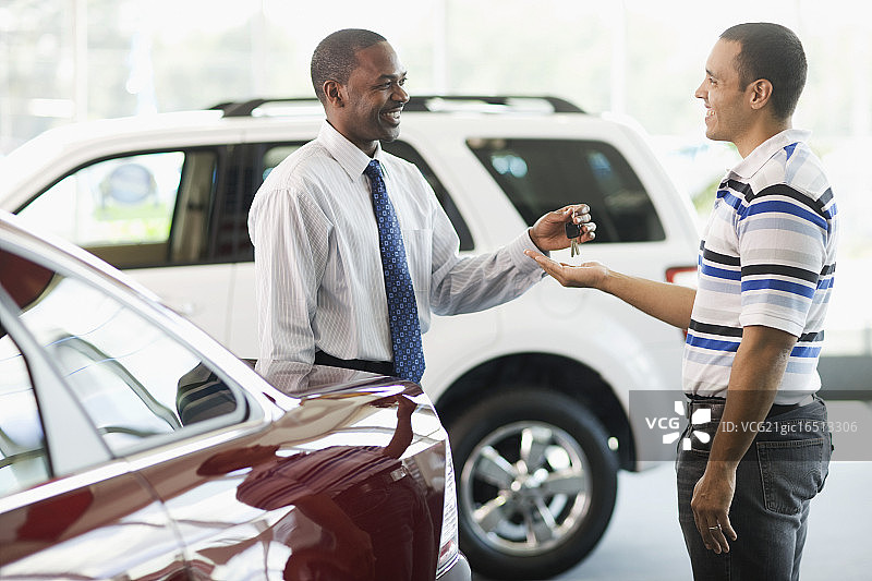 男销售员向男子交付新车钥匙图片素材