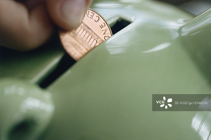 将硬币放入存钱罐图片素材