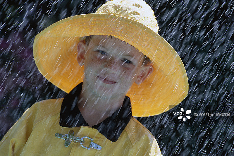 戴着雨帽和雨衣的男孩图片素材
