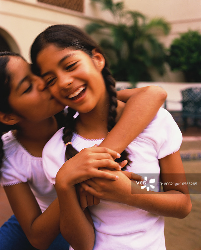 拥抱和亲吻的双胞胎姐妹图片素材