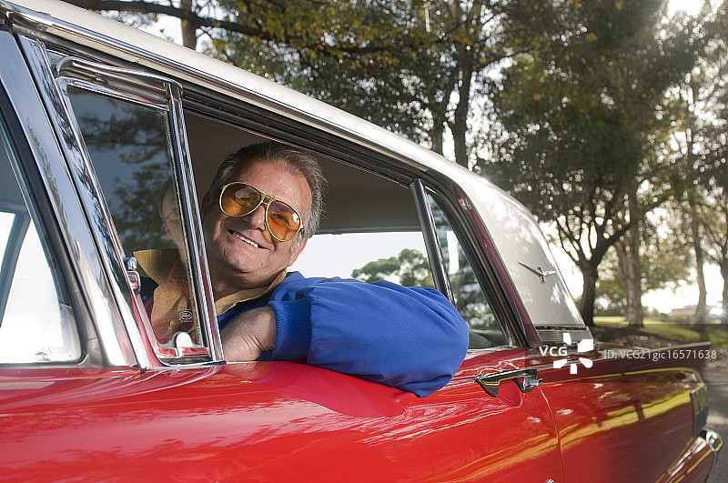 年长的男人驾驶福特雷鸟汽车图片素材